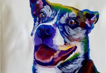 Colorful dog with mouth open, smiling